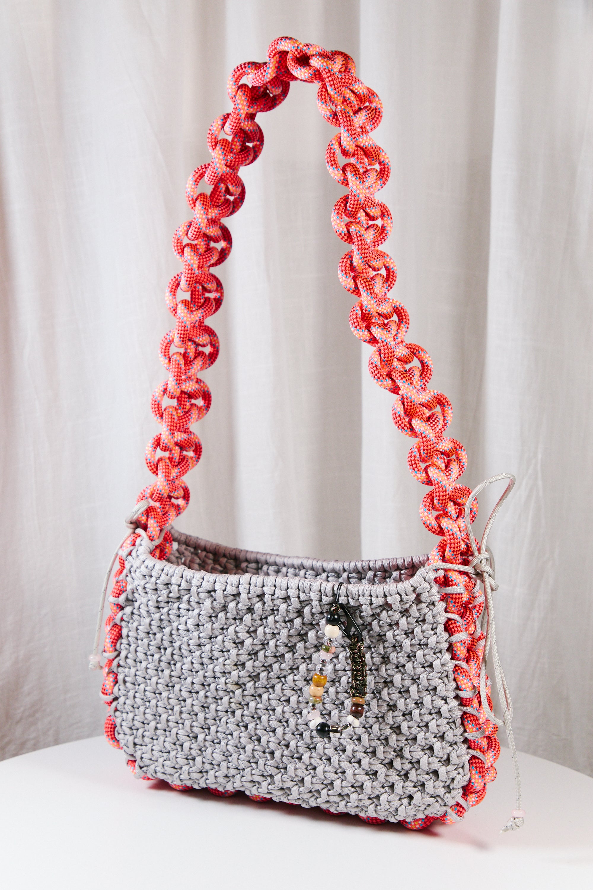 Nots friday sling bag in coral and grey reflective