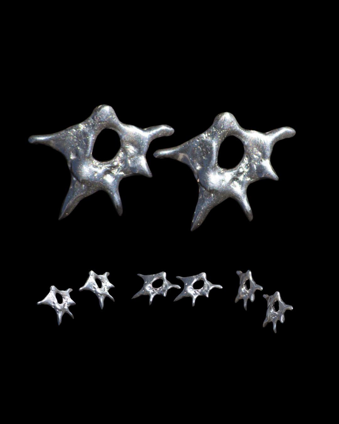 Pair of silver spike earrings on a black background