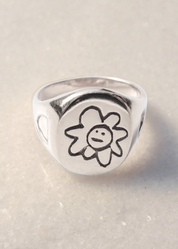 Silver ring with a flower design on a light background